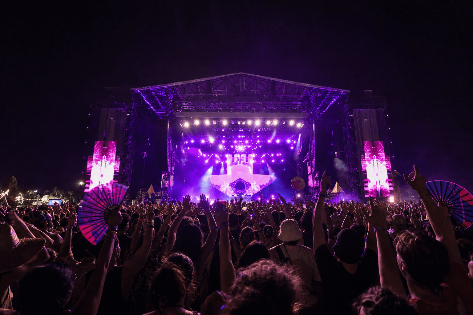 Festival crowd facing the main stage at night