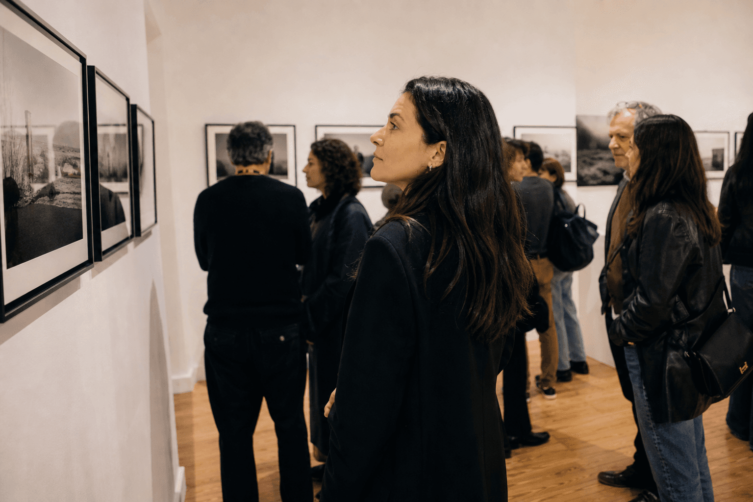 Guests at a Lisbon gallery opening viewing documentary prints